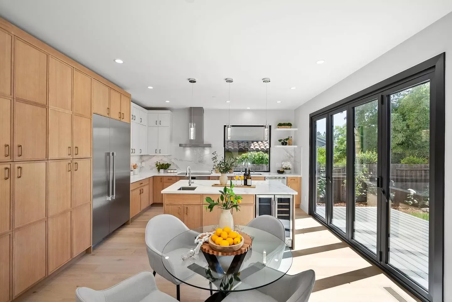 Oak kitchen remodel with floor-to-ceiling cabinetry and black-framed patio doors